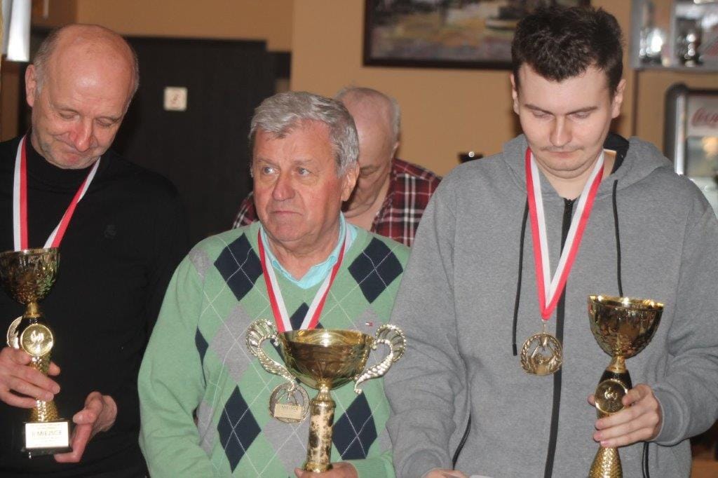 Trzej mężczyźni z medalami i pucharami w rękach