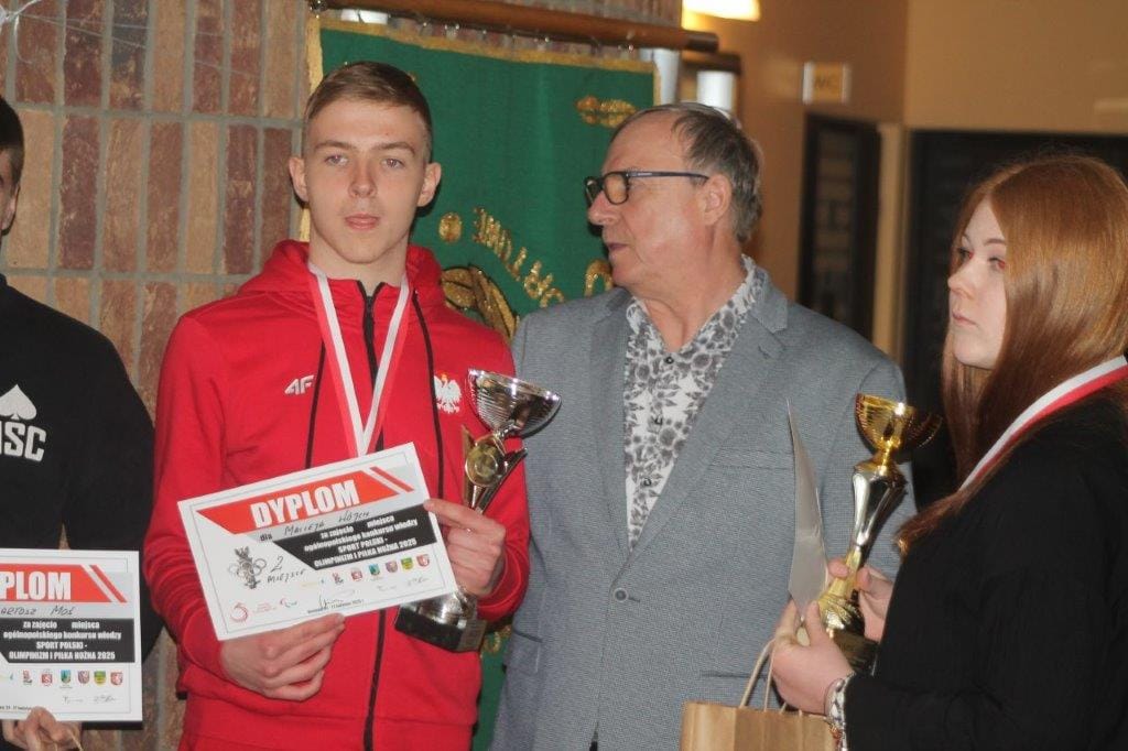 Młodzi ludzie z dyplomami i trofeami na ceremonii