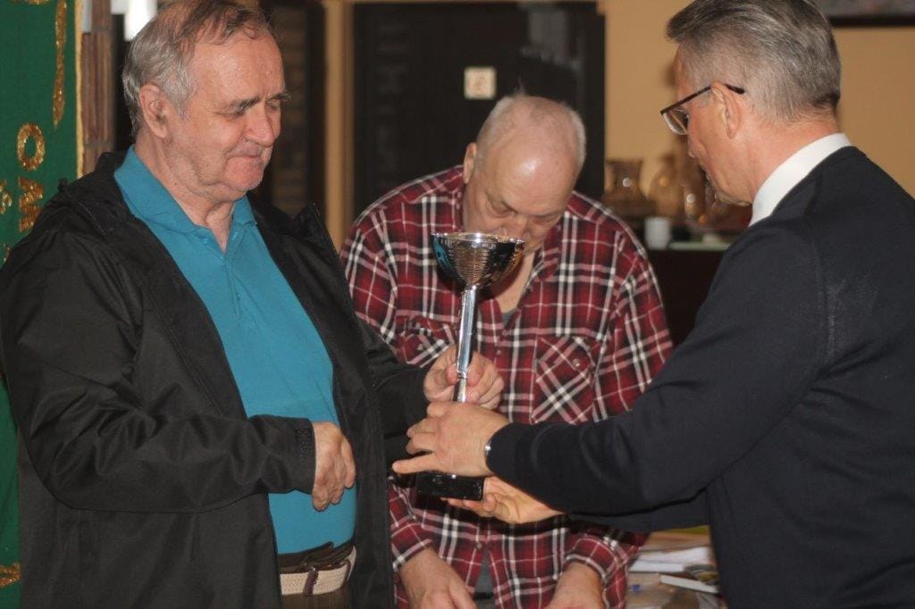 Trzech mężczyzn, wręczenie pucharu w pomieszczeniu