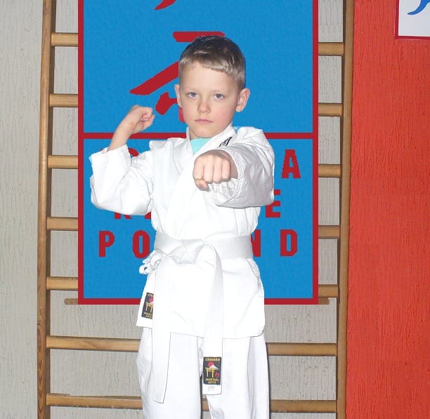 Chłopiec w białym kimono trenuje karate