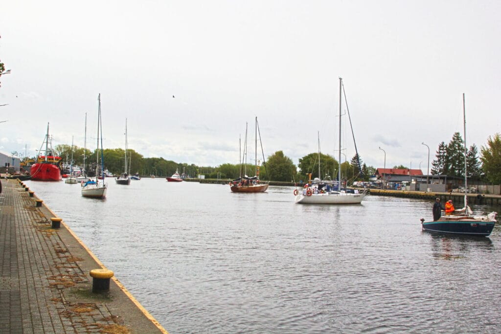 Łodzie żaglowe i kutry rybackie na spokojnej rzece