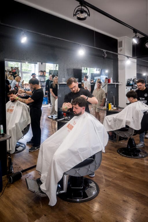 Fryzjerzy pracują nad strzyżeniem mężczyzn w salonie