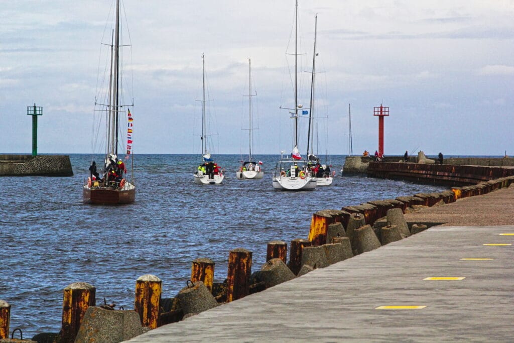 Łodzie żaglowe wpływające do portu morskiego