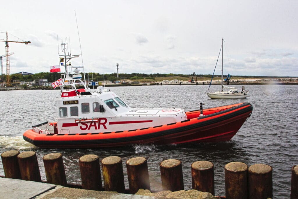 Łódź ratunkowa SAR i żaglówka na tle portu