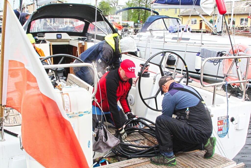Załoga przygotowuje jacht do żeglugi w porcie