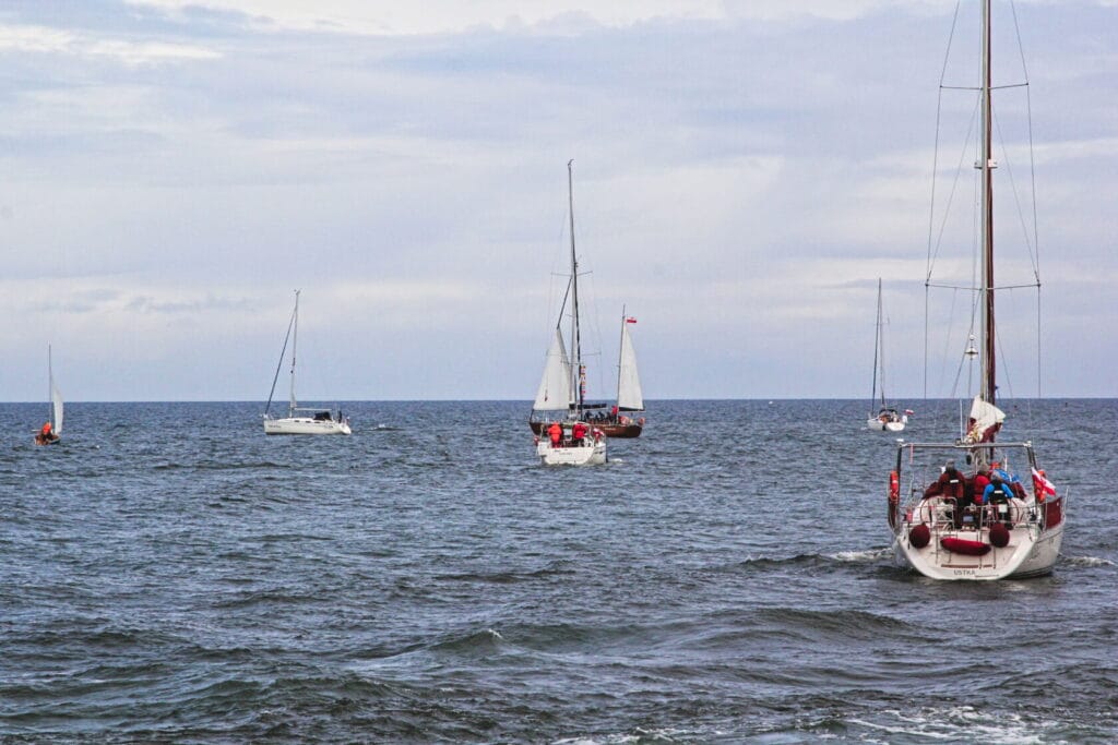 Żaglówki na otwartym morzu pod zachmurzonym niebem