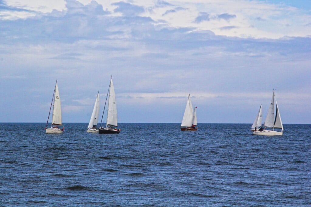 Żaglówki płynące na spokojnym morzu