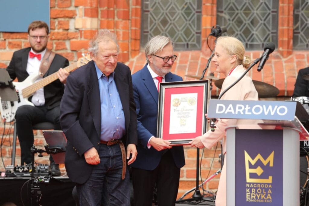 Wręczanie nagrody w Darłowie, osoby z dyplomem i muzyk
