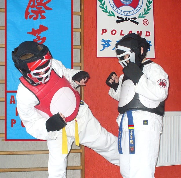 Dzieci trenujące taekwondo w ochronnych kaskach