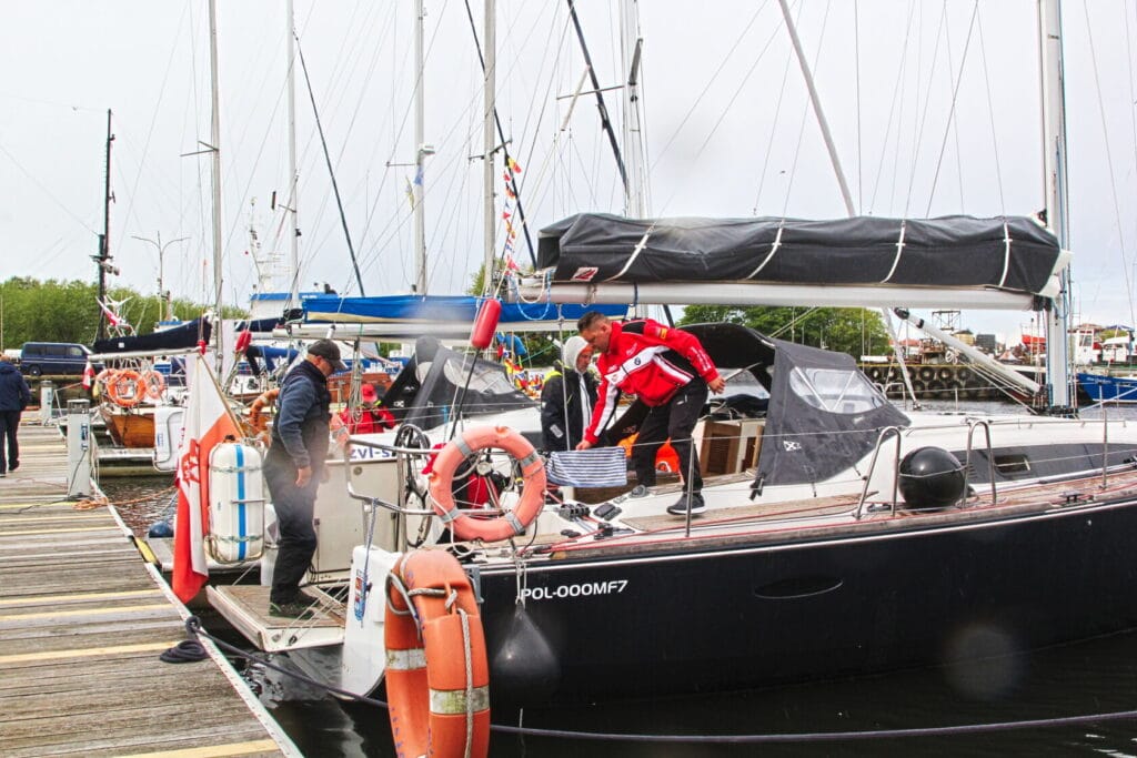 Ludzie przygotowują jacht do żeglowania w marinie