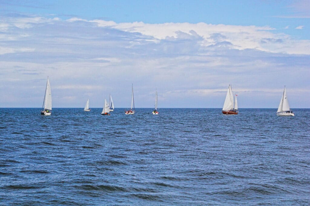 Żaglówki płynące na otwartym morzu, niebieskie niebo