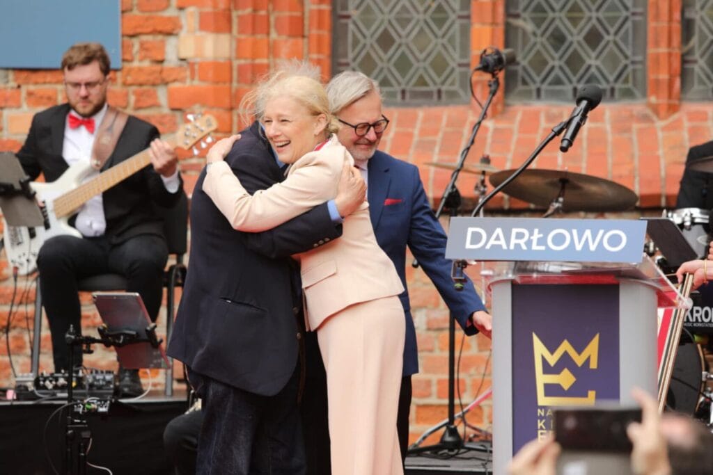 Kobieta i mężczyzna przytulają się na scenie w Darłowie