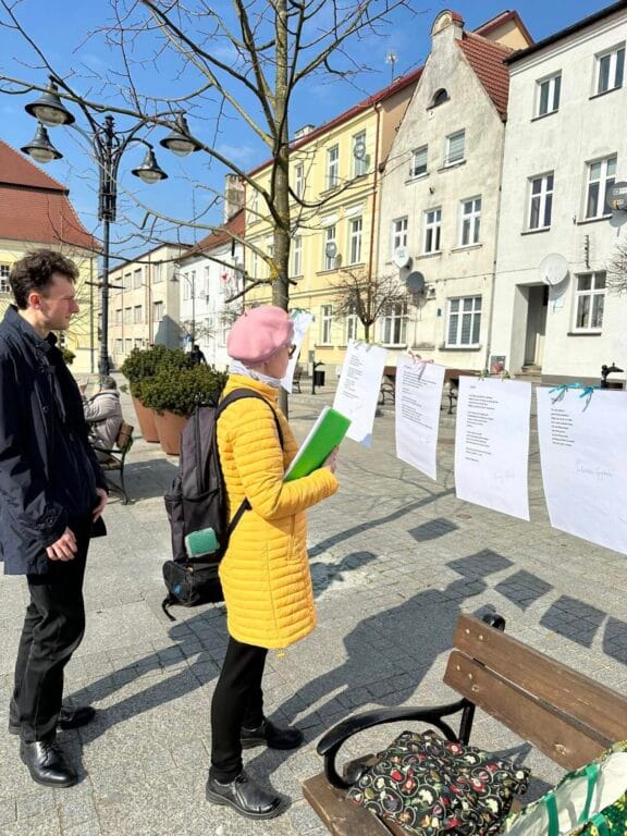 Ludzie czytają ogłoszenia na zewnętrznej tablicy ogłoszeń