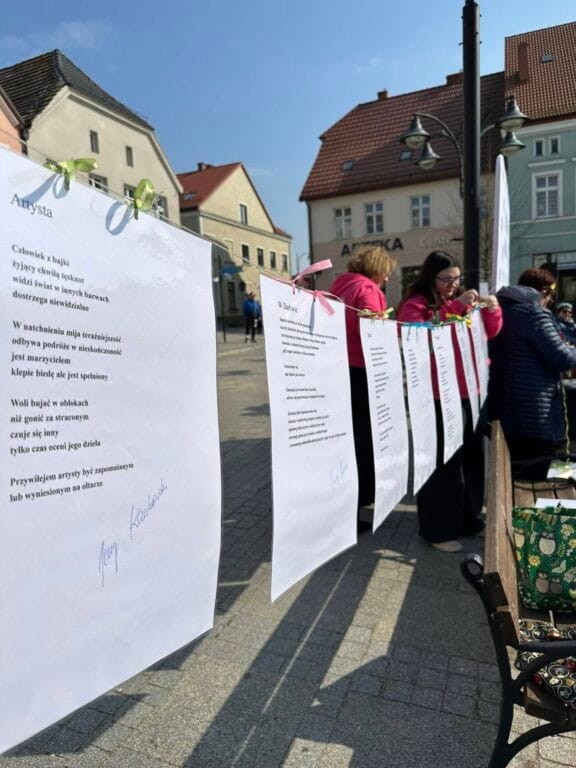 Uliczna wystawa poezji z ludźmi w tle