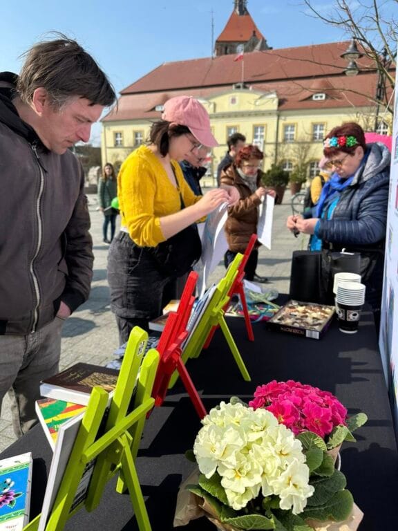 Ludzie przeglądają książki na stoisku na placu