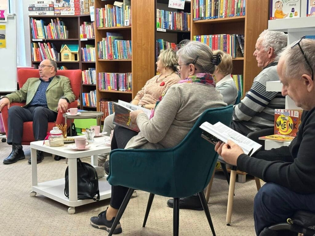 Seniorzy czytający książki w bibliotece