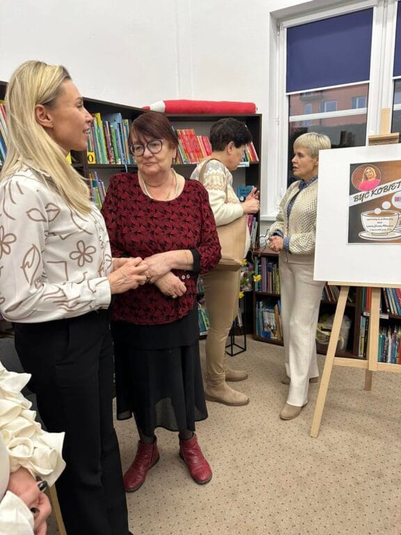 Kobiety rozmawiają w bibliotece obok półek z książkami