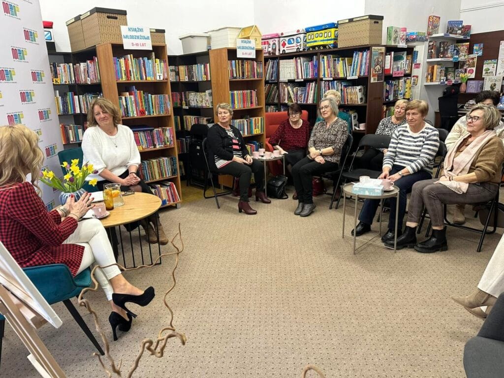 Kobiety na spotkaniu w bibliotece dyskutują przy kawie