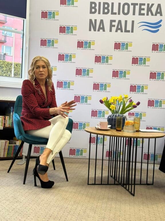 Kobieta dyskutuje na wydarzeniu w bibliotece