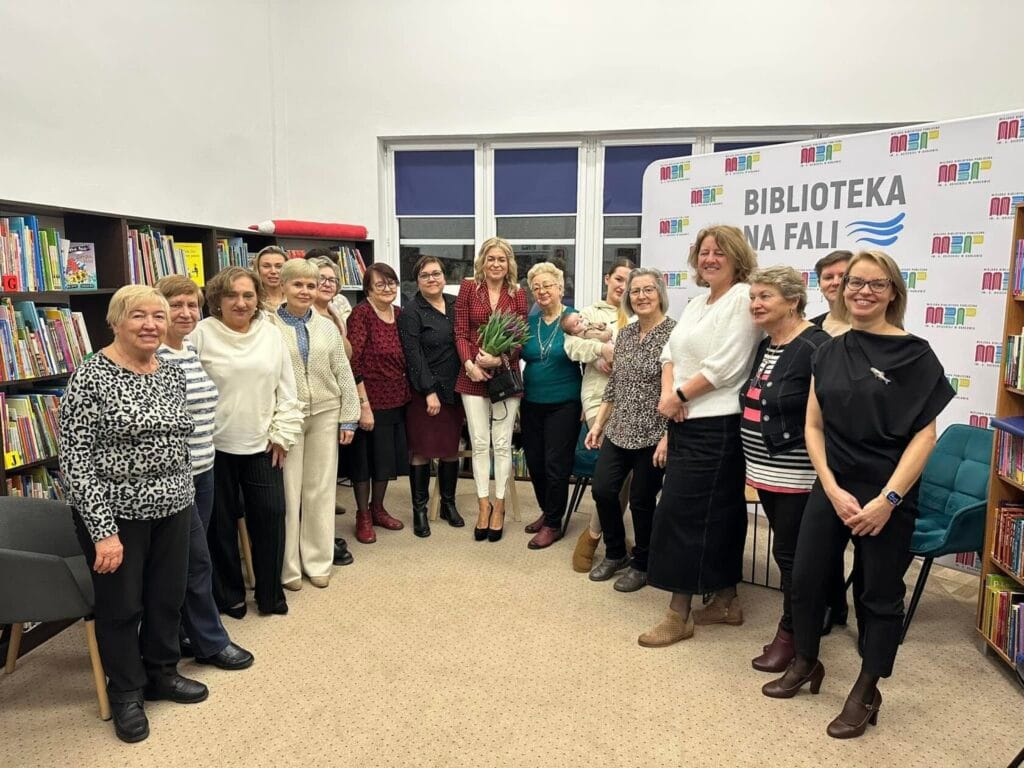 Grupa osób pozuje w bibliotece