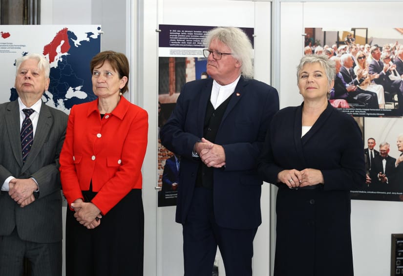 Cztery osoby stojące przed wystawą historyczną