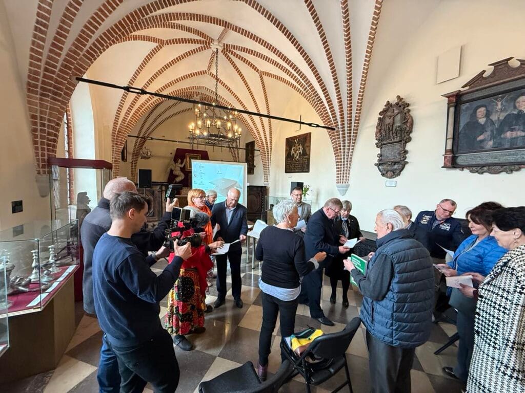 Grupa osób uczestnicząca w wydarzeniu kulturalnym wewnątrz