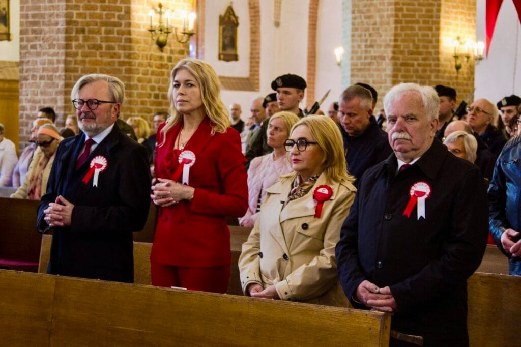 Osoby z kotylionami w kościele na uroczystości