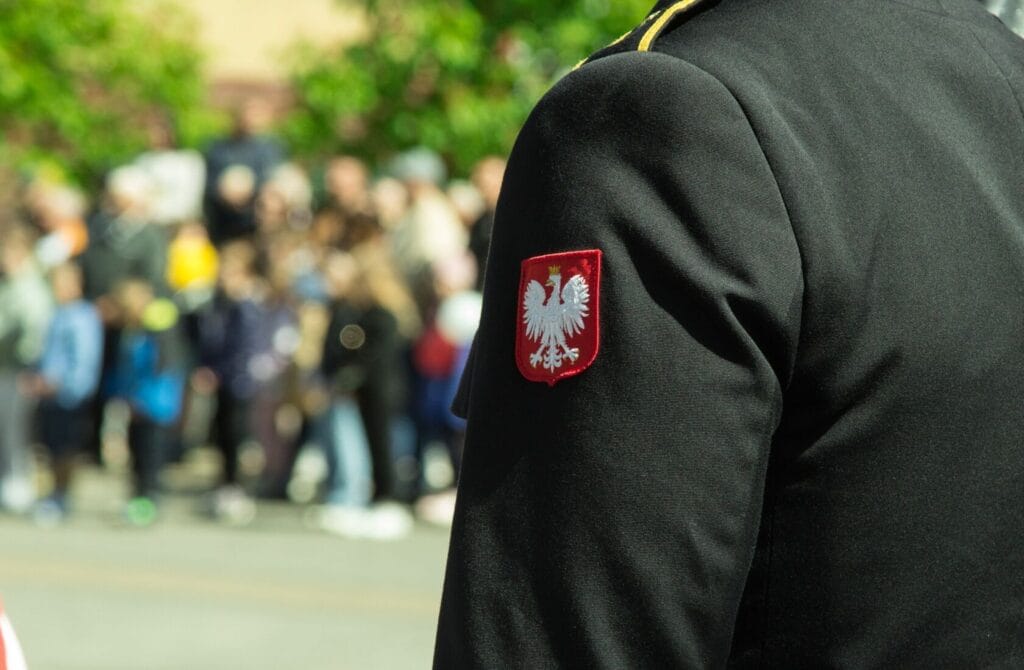 Mundur z godłem Polski, tłum w tle