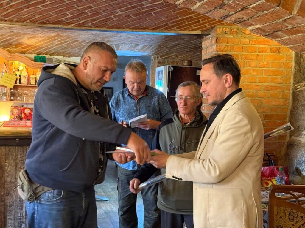 Mężczyźni wymieniają informacje w rustykalnym wnętrzu.