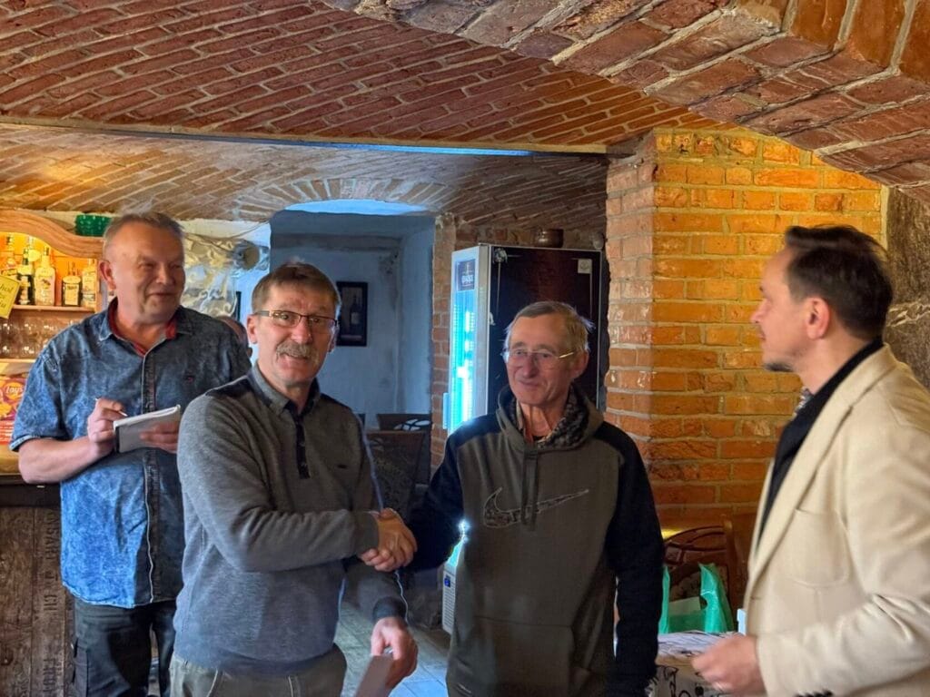 Czterech mężczyzn w historycznym wnętrzu pod łukiem