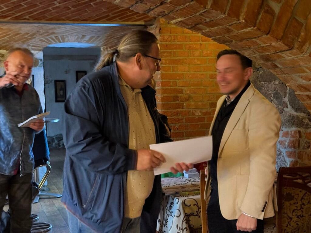 Dwóch mężczyzn rozmawia w murowanym wnętrzu