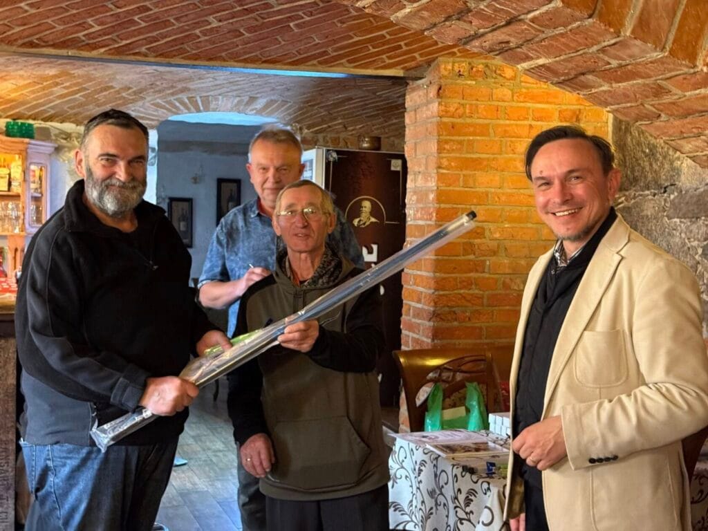 Czterech mężczyzn trzyma fluorescencyjną rurę w piwnicy