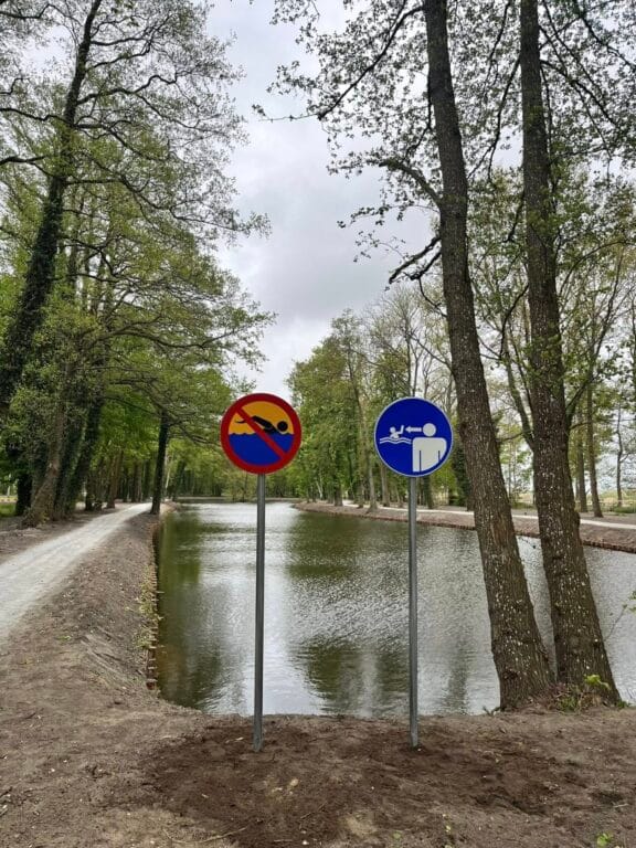 Znaki drogowe zakaz parkowania i wjazdu przy stawie