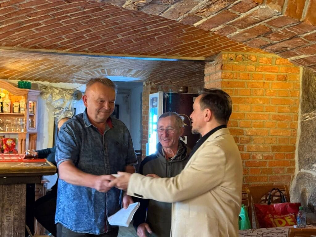 Trzej mężczyźni uścisk dłoni w ceglanych wnętrzach