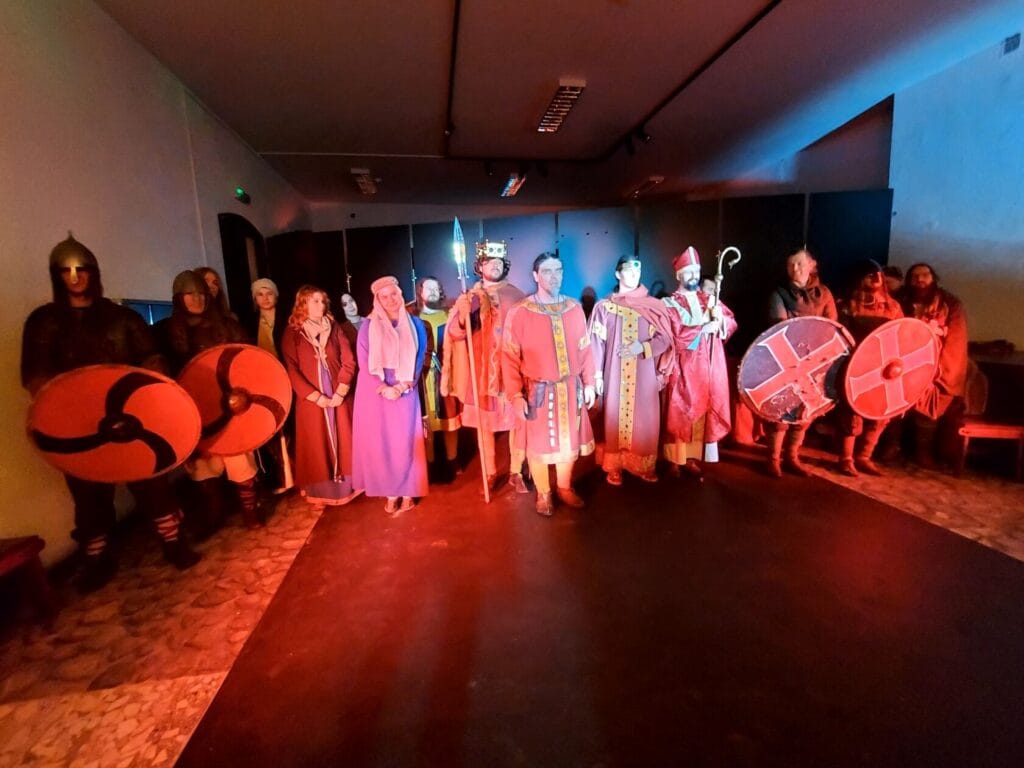 Grupa osób w historycznych strojach średniowiecznych