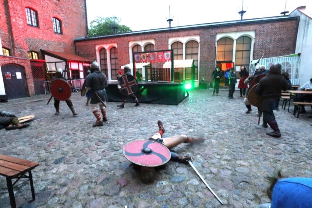 Historyczna rekonstrukcja walki wojów na zamkowym dziedzińcu