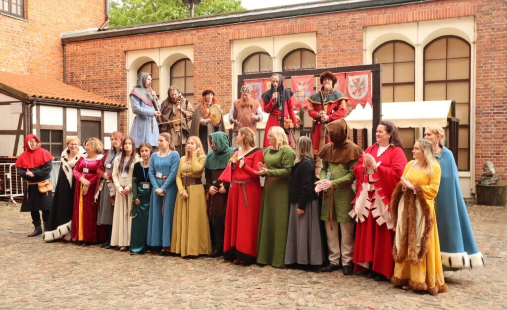 Grupa osób w historycznych strojach podczas rekonstrukcji