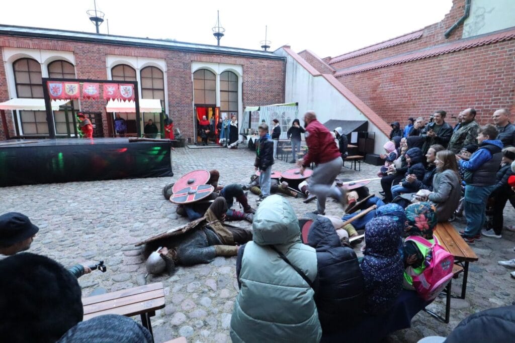 Rekonstrukcja historyczna na dziedzińcu z widzami