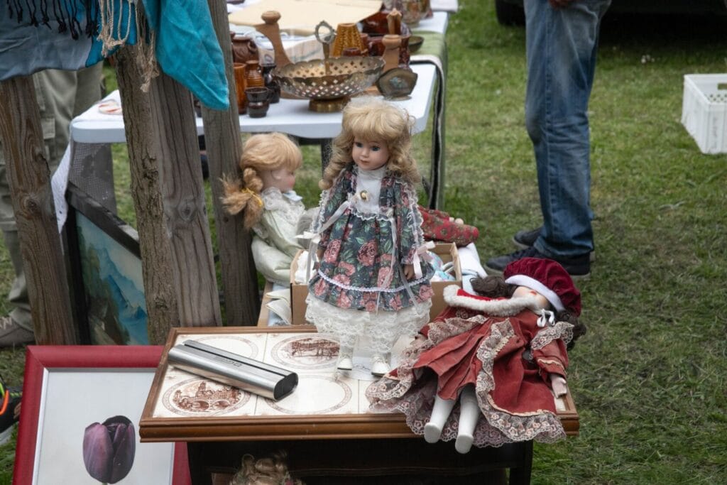 Lalki i przedmioty na stoisku targowym.