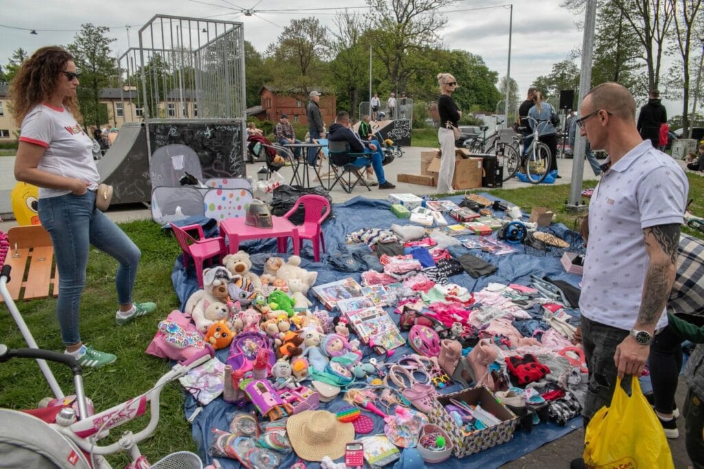 Ludzie na targu pchlim, sprzedający i przeglądający różne przedmioty