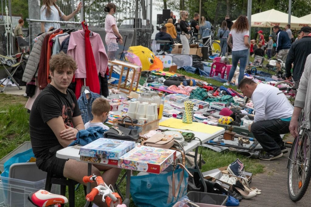 Ludzie na zewnątrz podczas targu garażowego z różnymi przedmiotami
