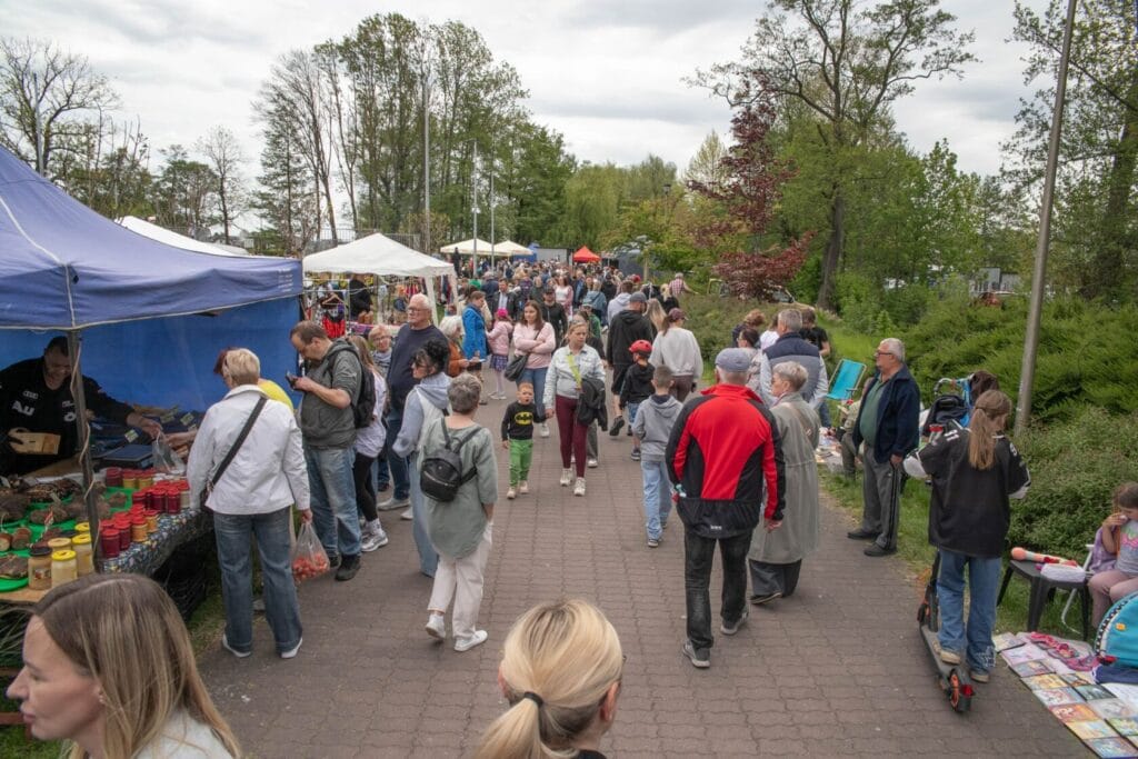 Ludzie spacerują między straganami na zewnątrznym targu
