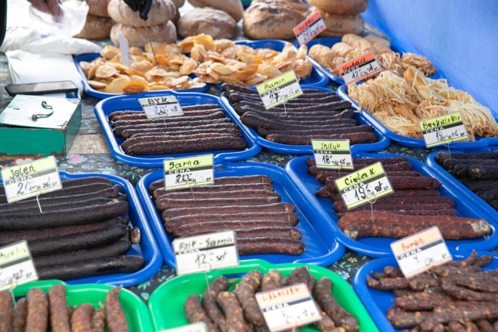 Targ z różnorodnymi wędlinami i cenami na etykietach