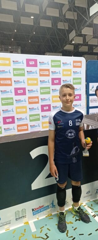 Chłopiec sportowiec z&nbsp;trofeum na&nbsp;tle banerów Kinder