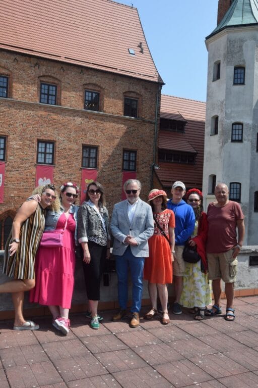 Grupa osób przed historycznym budynkiem.