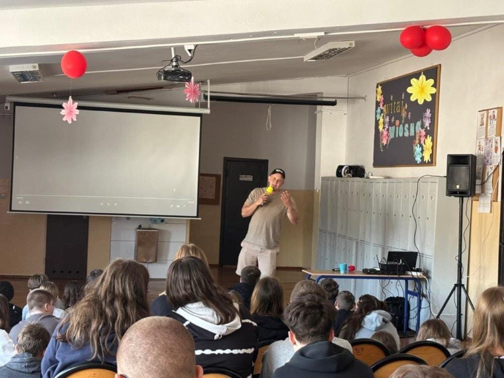 Prezentacja w szkole, mężczyzna mówi do uczniów