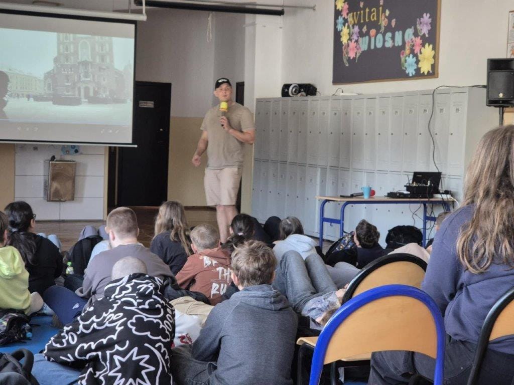 Mężczyzna prezentuje slajd przed grupą uczniów