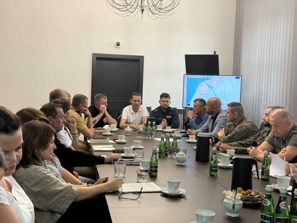 Grupa ludzi dyskutuje przy stole konferencyjnym