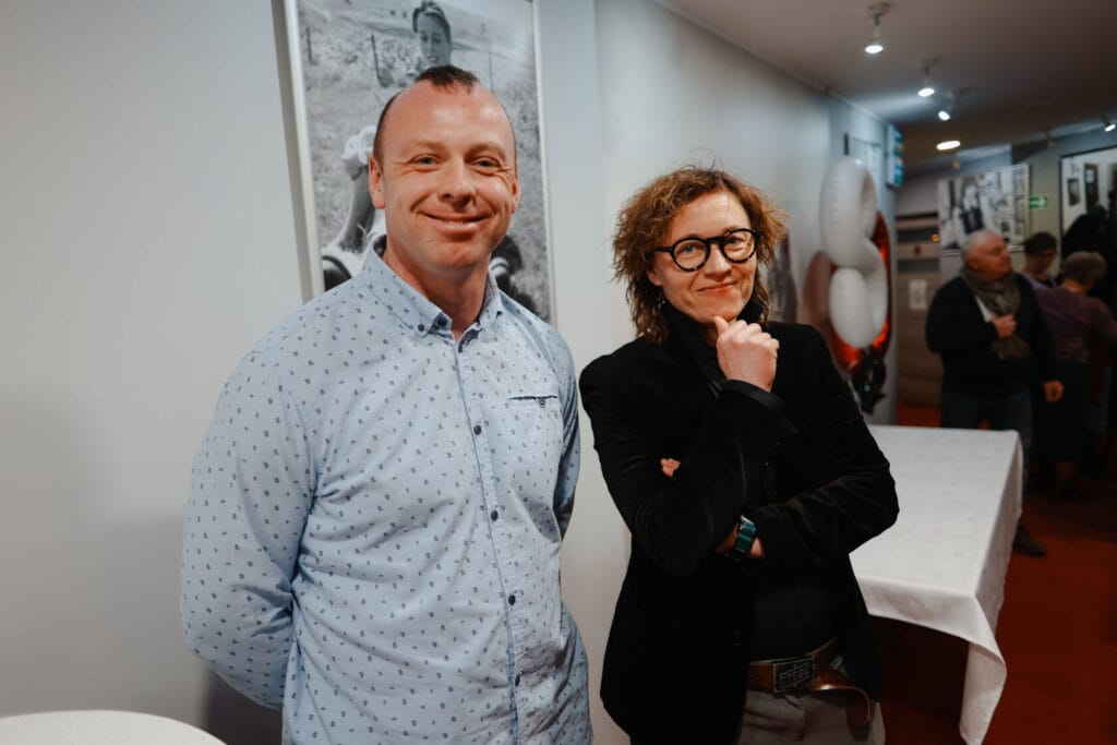 Dwoje uśmiechniętych osób w wewnętrznym pomieszczeniu