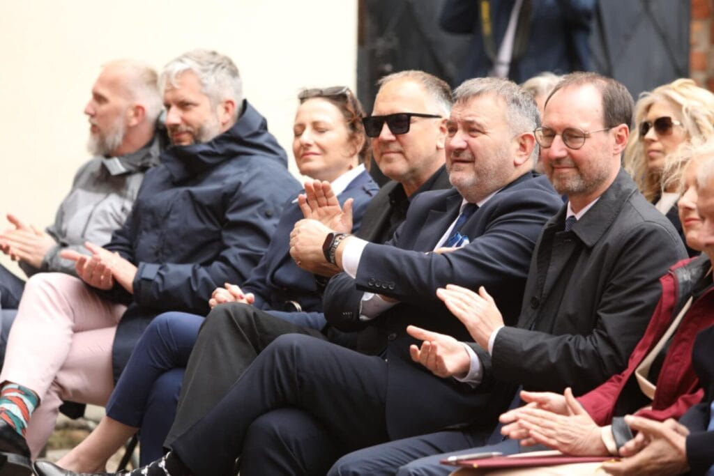 Grupa ludzi klaskających na zewnętrznym wydarzeniu